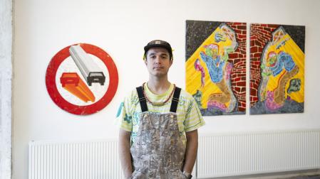 Matías Oficialdegui entre una de las señales de tráfico reales sobre la que ha estampado cadenas, candados o llaves inglesas y el díptico 'Los borrachos'
