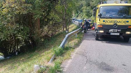Bomberos de Llanes trabajan en el lugar en el que se salió de la vía el automóvil