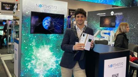 Ignacio Cires de Orbe, en un stand de la empresa, sujeta un modelo de satélite