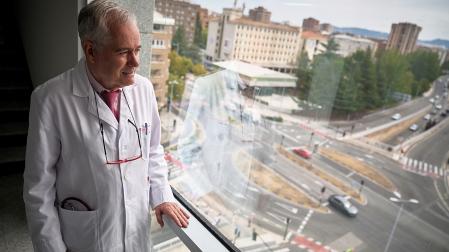 El Dr. José Rifón Roca mira al exterior desde una ventana de la séptima planta de la Clínica Universidad de Navarra