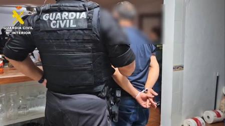 Un agente de la Guardia Civil arresta a uno de los implicados en la operación Gecaroni