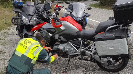 Un agente de la Guardia Civil, junto a la motocicleta accidentada