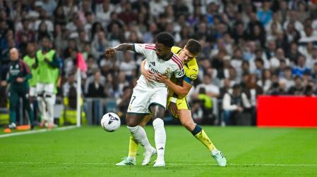 El delantero del Real Madrid Vinicius Jr (delante) lucha por el balón con Juan Foyth (detrás), del Villarreal CF, durante el partido
