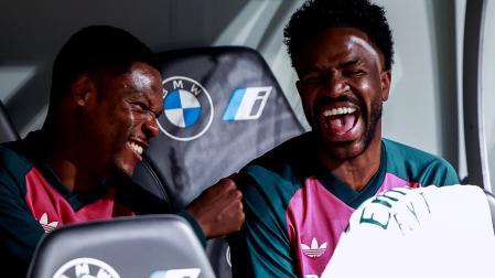 El delantero del Real Madrid Vinicius Junior sonríe junto a su compañero, Denzel Dumfries, en el banquillo durante el encuentro contra el Villarreal