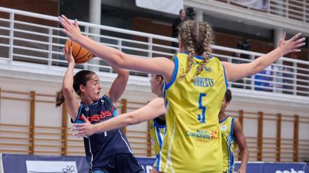 Celia García, nuevo fichaje del Osés Construcción, trata de conceder un pase ante la defensa de dos jugadoras del Spar Gran Canaria