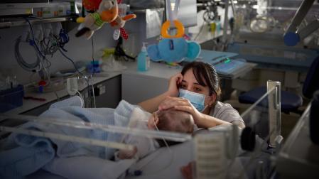Una enfermera acaricia a un bebé en la Unidad de Neonatología del Complejo Hospitalario de Navarra (CHN), en una imagen de 2023.