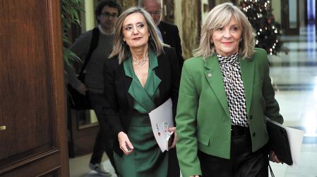 María Caballero y, detrás, Cristina Ibarrola, en una imagen en la que ambas entran a un pleno municipal de Pamplon