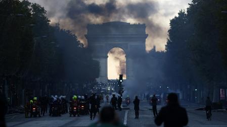 Agentes de policía se enfrentan a manifestantes durante una protesta contra el aumento del costo de vida y los recortes en los servicios públicos en los Campos Elíseos, en París.