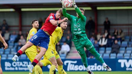 El portero del Olot, Pol Ballesté, captura el balón ante el salto del delantero del Promesas, Lucas Díaz