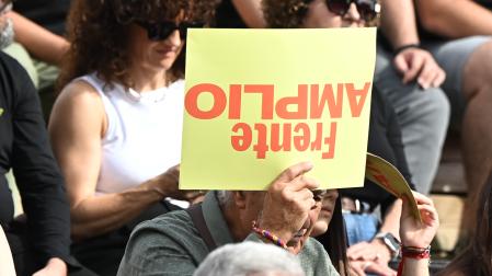 Un asistente a la presentación este sábado 17 de octubre de Frente Amplio en Madrid sujeta un cartel al revés con el nombre de la coalición