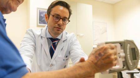El Dr. Miguel Germán Borda realiza la prueba de sarcopenia con el dinamómetro de mano a uno de sus pacientes