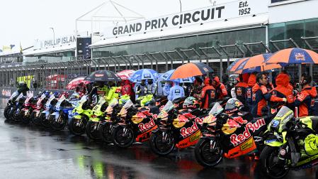 Las motos de MotoGP esperan en la parrilla de salida cubiertas por paraguas antes de la cancelación del GP de Australia en el circuito de Phillip Island