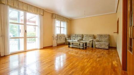 Salón con acceso y ventanales al jardín