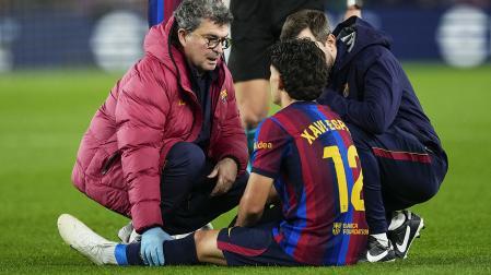 El defensa del Barcelona Xavi Espart recibe atención médica tras lesionarse durante el clásico