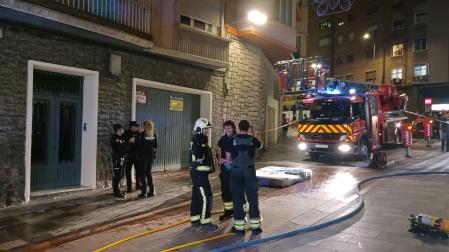 Bomberos y policías, en la calle Eza, con el colchón que ardió en el piso y que se lanzó a la calle