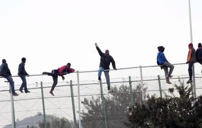 Decenas de inmigrantes se encaraman a la valla de Melilla