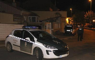Un coche de la Guardia Civil junto a la vienda donde los cadáveres de un hombre y una mujer han sido hallados