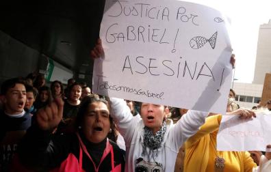 Foto de un centenar de personas pidiendo justicia al paso del furgón donde se halla Quezada