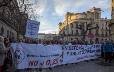 Jóvenes y mayores salen a la calle en Pamplona bajo la lluvia