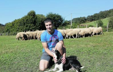Julen Arburua Jiménez, con uno de sus perros, y parte de su rebaño, en Lekaroz.