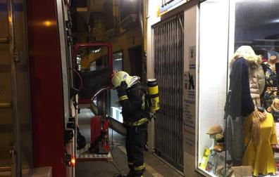 Un bombero ante el portal de la calle Zapatería de Pamplona donde se produjo el incendio