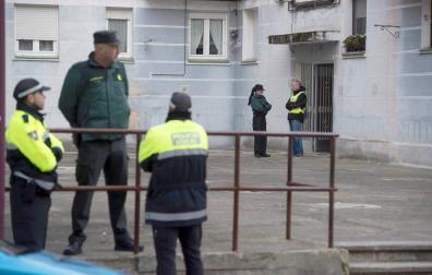 Agentes de la Guardia Civil en el portal del domicilio en el que una mujer de 26 años ha sido asesinada a puñaladas supuestamente por su novio en Laredo.