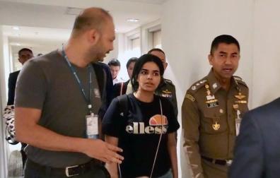 La joven saudí, Rahaf Mohammed Al-Qunun (c), conversa con el jefe de la policía de inmigración de Tailandia, Surachet Hakparn (d), y un trabajador de ACNUR (i) antes de abandonar el aeropuerto Suvarnabhumi en Tailandia.