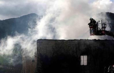 Bomberos del Gobierno de Navarra y agentes de la Policía Foral trabajan en el incendio que esta madrugada ha calcinado una vivienda en la localidad de Artaiz (Unciti).