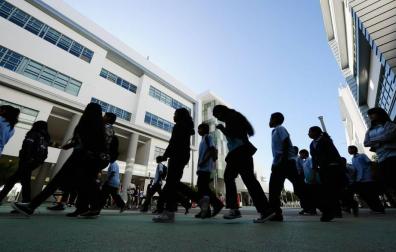 Estudiantes a la entrada de un colegio.