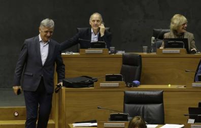 Martínez (Geroa Bai) baja las escaleras del hemiciclo entre Araiz (Bildu) y la presidenta Barkos.