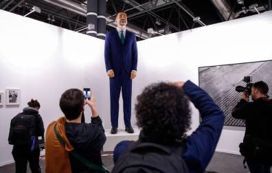 Varias personas observan el "ninot" del rey Felipe VI ,una obra de Santiago Sierra y Enrique Merino, expuesta en ARCO 2019.