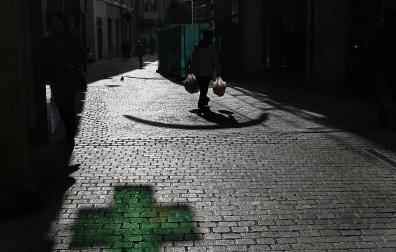 Imagen del reflejo de la cruz de una farmacia.