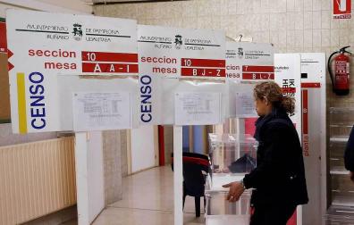 Trabajadores del Ayuntamiento de Pamplona durante la colocación de los paneles, urnas y papeletas en un colegio electoral de la capital navarra.