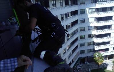 Un bombero, en la ventana de la mujer en la calle Abejeras.