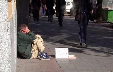 Una persona pide dinero en la calle.