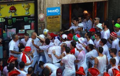 Jóvenes y policías municipales de paisano durante el forcejo en el portal.