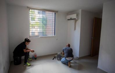 Foto que muestra a un hombre trabajando en una habitación de una de las viviendas que mantienen Silvia Fuenmayor y Amelí Mata a sus clientes en Caracas (Venezuela)