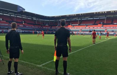 Los cadetes de Osasuna disputan el partido de ensayo ante la mirada del cuarteto arbitral.