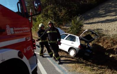 Bomberos, en el lugar del accidente, con el vehículo detrás.