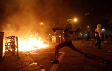 Un manifestante corre frente al fuego durante los disturbios en la Plaza de Urquinaona, en Barcelona a 18 de octubre de 2019.