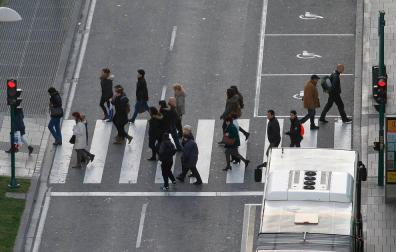 Varias personas cruzan un paso de peatones de Pamplona.
