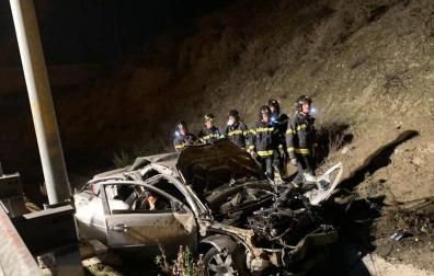 Bomberos de Madrid junto al coche accidentado en la M50.