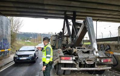 Imagen de la Guardia Civil regulando el tráfico tras el choque de la grúa -a la derecha- con el puente.