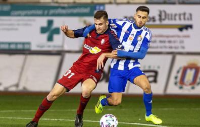 Barbero, delantero de Osasuna, intenta alcanzar el balón ante el defensa del Lorca Óscar Oliva.