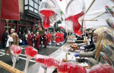 La procesión de San Blas pasa ante el tradicional mercadillo de roscos y dulces.