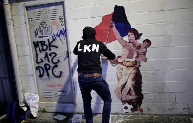 El artista LKN coloca el dibujo en homenaje a Maider Irisarri, anoche en la calle Nueva junto a la plaza San Francisco de Pamplona.