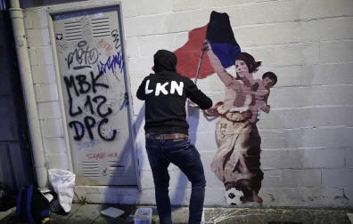 El artista LKN coloca el dibujo en homenaje a Maider Irisarri, anoche en la calle Nueva junto a la plaza San Francisco de Pamplona.
