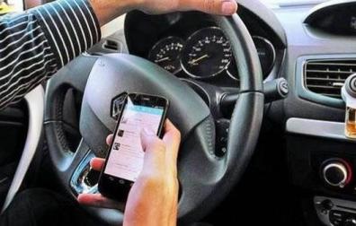 Un conductor usando el móvil al volante