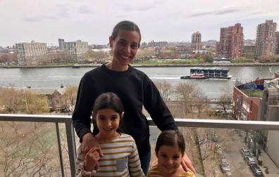 La adrianesa Amaya Guillermo Jiménez con sus dos hijas, Julia y Manuela, en el balcón de su casa de Manhattan, con el East River detrás.