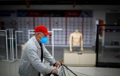 Un hombre empuja un carrito de la compra en Beijing.